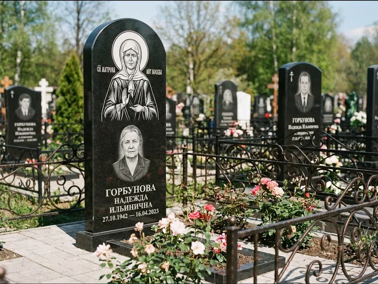Памятник с гравировкой иконы: стела с арочным верхом и киотом под образ — гравировка образа Матроны Московской, гранитный цоколь с тёмной плиткой, работа «Ковалёв» в Ульяновске