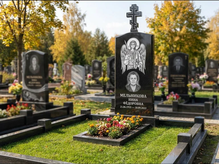 Памятник с гравировкой иконы: округлая стела-медальон с ликом — гравировка Богородицы «Семистрельная», луговые травы и полевые цветы за участком, работа «Гущин» в Ульяновске