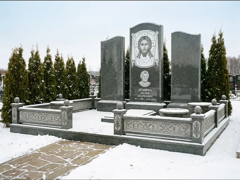 Памятник с гравировкой иконы: узкая вертикальная стела-пилон с ликом — икона в резной рамке-киоте, открытая лужайка без ограды, работа «Одинцов» в Ульяновске