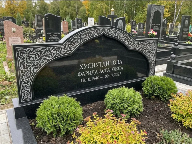 Мусульманский памятник: вытянутая горизонтальная семейная стела с аркой — белая гравировка силуэта мечети с минаретами, участок с декоративными кустами, работа «Зарипова» в Ульяновске