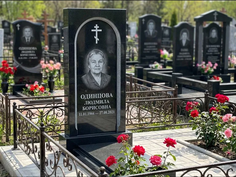 Памятник из чёрного гранита — скромная невысокая стела с крестом с терновым венцом, работа «Лаврентьева» в Ульяновске