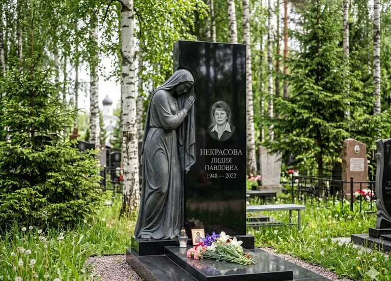 Гранитная фигура скорбящего мужчины у чёрной стелы в Ульяновске