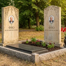 Памятник из светлого известняка арочной формы с цветами на двоих